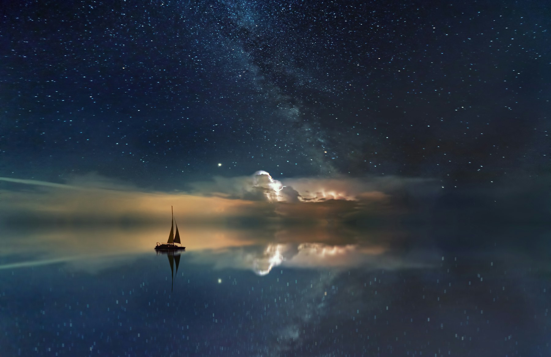 Night sky reflected across a quiet lake